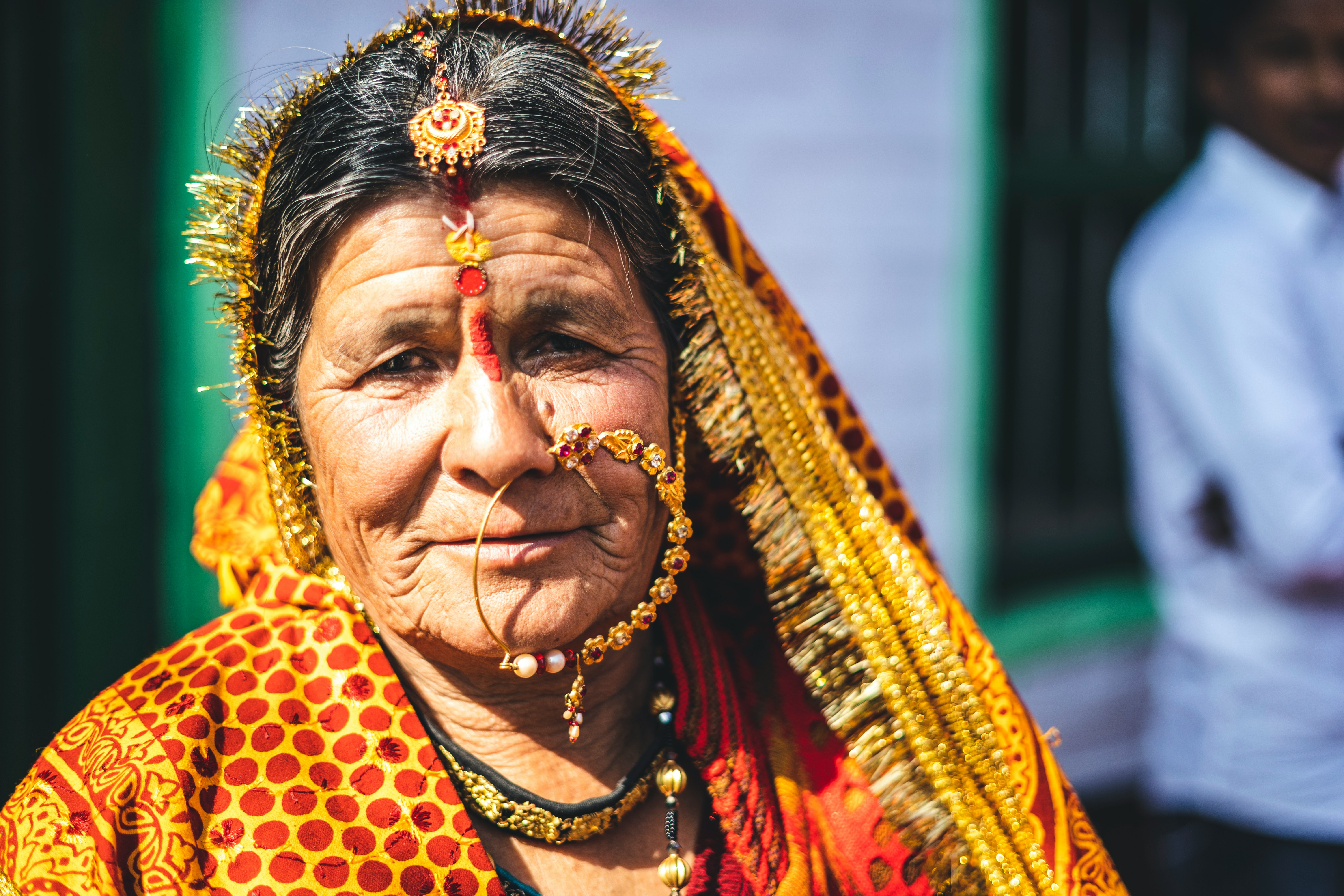 woman in yellow and brown sari wearing gold necklace